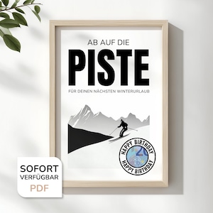 Könnte beinhalten: Gerahmter Druck mit den Worten "AB AUF DIE PISTE" in großen schwarzen Buchstaben, mit einer Skifahrer-Illustration und dem Text "FÜR DEINEN NÄCHSTEN WINTERURLAUB". Ein "Happy Birthday"-Aufkleber befindet sich unten rechts. Der Druck ist in einem hellen Holzrahmen.