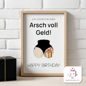 May include: A framed print with the text "ZUM GEBURTSTAG EINEN: Arsch voll Geld! HAPPY BIRTHDAY" and a graphic of a black silhouette of a rear end filled with money. The frame is light brown.
