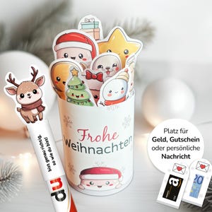 Może przedstawiać: Biały pojemnik na prezenty o tematyce świątecznej ze słowami "Frohe Weihnachten" i różnymi postaciami z kreskówek. Zawiera renifera, bałwana i Świętego Mikołaja. Pojemnik jest przeznaczony do przechowywania pieniędzy, kart podarunkowych lub wiadomości osobistych.