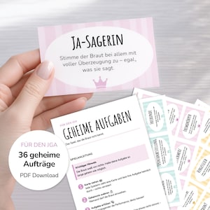 May include: A set of pink and white bridal shower game cards. One card reads "JA-SAGERIN" with text below. Other cards have instructions and tasks. The set includes 36 secret tasks, available as a PDF download.