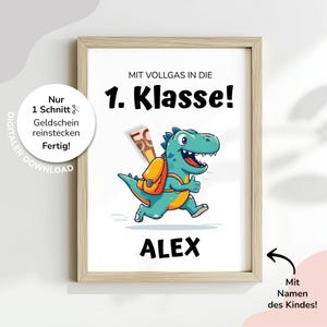 Könnte beinhalten: Gerahmter Druck mit einem Cartoon-Dinosaurier, der einen Rucksack trägt und läuft. Der Text "1. Klasse!" steht über dem Dinosaurier, darunter der Name "ALEX". Zusätzlicher Text: "Nur 1 Schnitt & Geldschein reinstecken Fertig!" und "Mit Namen des Kindes!"