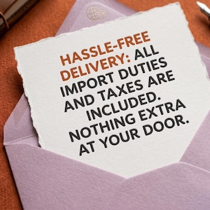 May include: A square piece of white paper with deckled edges featuring the text: HASSLE-FREE DELIVERY: ALL IMPORT DUTIES AND TAXES ARE INCLUDED. NOTHING EXTRA AT YOUR DOOR. The paper is placed inside a light purple envelope with a wax seal.