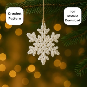 May include: A cream-coloured crocheted snowflake hanging from twine, set against a backdrop of Christmas tree foliage and golden bokeh lights. The text "Crochet Pattern" and "PDF Instant Download" are in white boxes.