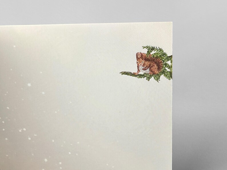 Op de afbeelding: Een wenskaart met een gedetailleerde illustratie van een bruin eekhoorntje op een groene tak. Het eekhoorntje kijkt naar voren, met zijn pluizige staart zichtbaar. De achtergrond is een zachte, gebroken witte kleur met subtiele witte spikkels.