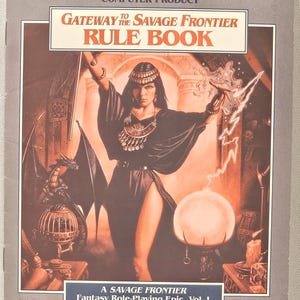 May include: A vintage "Advanced Dungeons & Dragons" computer product box. The cover art features a woman in a dark dress with a dragon and lightning bolts. The text reads "Gateway to the Savage Frontier Rule Book" and "A Savage Frontier Fantasy Role-Playing Epic, Vol. I."