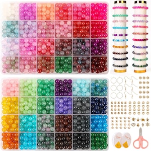 May include: A craft kit with a variety of colorful beads in a clear organizer. The beads are in shades of pink, red, green, blue, and yellow. Also included are bracelets, earring hooks, and other jewelry-making supplies.