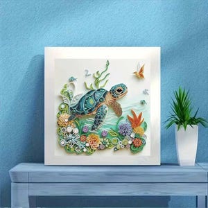 May include: A framed artwork featuring a detailed, colorful sea turtle swimming above coral and plants. The turtle has a teal shell with a patterned design. The artwork is set against a light blue background.