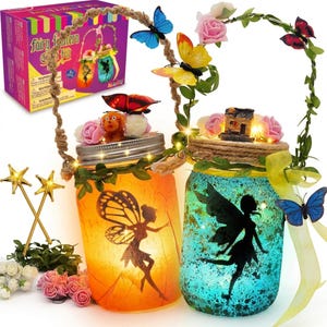 May include: A fairy lantern craft kit with two mason jars, each with a fairy silhouette. The jars are orange and teal, decorated with butterflies, flowers, and fairy lights. The kit includes star wands and a decorative box.