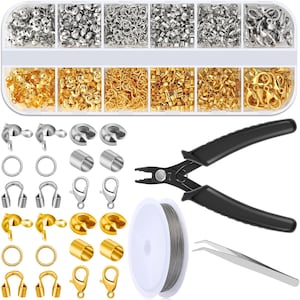 May include: A jewelry making kit featuring a clear plastic organizer box with twelve compartments filled with silver and gold-toned findings, including jump rings, crimp beads, and lobster clasps. Includes black handled pliers and silver wire.