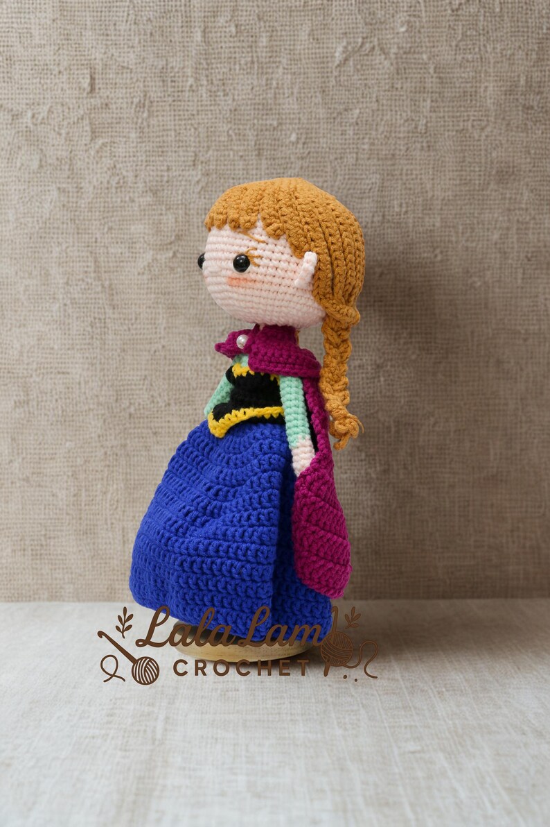 Puede incluir: Mu&ntilde;eca de ganchillo hecha a mano que se asemeja a un personaje de una popular pel&iacute;cula de animaci&oacute;n. La mu&ntilde;eca tiene un vestido azul, una capa morada y una trenza rubia. La mu&ntilde;eca mide unos 15 cm de altura.