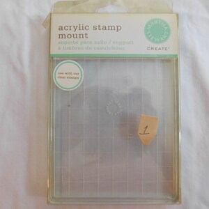 Puede incluir: Soporte transparente de acr&iacute;lico para sellos con un patr&oacute;n de cuadr&iacute;cula. El soporte est&aacute; etiquetado como "acrylic stamp mount" y "use with our clear stamps".