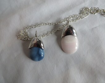 May include: A silver chain necklace with two pendants. One pendant is a light blue oval stone with a silver cap. The other pendant is a pink oval stone with a silver cap.