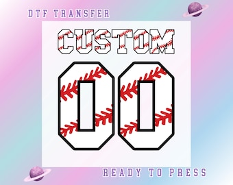 May include: A white DTF transfer with the word "CUSTOM" in black outlined letters with red baseball stitching. Below are the numbers "00" in a baseball design. The words "DTF TRANSFER" and "READY TO PRESS" are also present.