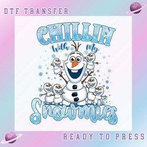 May include: A DTF transfer design featuring Olaf from Frozen with the text "Chillin' with my Snowmies." Olaf is surrounded by several small snowmen, all set against a white background with snowflakes. The words "Ready to Press" are also included.