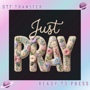 May include: DTF transfer design with the words "Just Pray" in a floral embroidered style. The letters are cream-colored with colorful flowers. The background is black, with a pastel gradient and planet graphics.