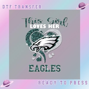 May include: A DTF transfer design featuring the text "This Girl Loves Her Eagles" in a script font, with the Eagles logo inside a heart shape. The design includes glitter accents and small hearts.