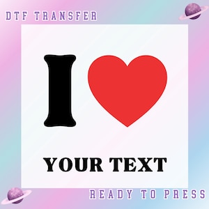 May include: A DTF transfer design with a black letter "I" and a red heart, with the words "YOUR TEXT" in bold black font. The design is set against a white background with a pastel gradient. The text "READY TO PRESS" is also included.