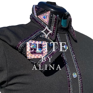 Könnte beinhalten: Schwarzes Reitshirt mit Kragen und Manschetten, die mit lila, rosa und irisierenden Strasssteinen verziert sind. Das Shirt trägt den Text "ELITE BY ALINA" in Weiß. Das Shirt hat eine Knopfleiste.