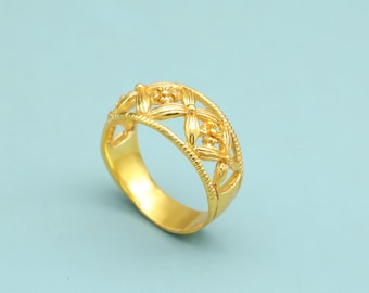 May include: A gold-colored ring with a floral filigree design. The ring features a band with a series of openwork flower shapes, creating a delicate and ornate appearance. The ring is set against a light blue background.