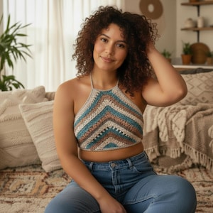 May include: A handmade crochet halter top in a chevron pattern. The top features stripes of beige, teal, and brown. The top is worn with blue jeans. The style is bohemian and casual.