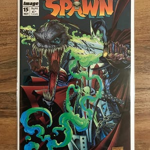 May include: Spawn comic book cover with a detailed illustration of the Spawn character in a red cape and chains. The cover includes the text "Spawn" and issue details, with vibrant green and blue energy effects.