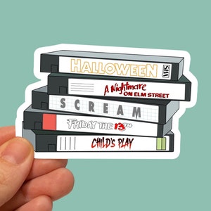 May include: A stack of five VHS tapes with titles "Halloween", "A Nightmare on Elm Street", "Scream", "Friday the 13th", and "Child's Play".