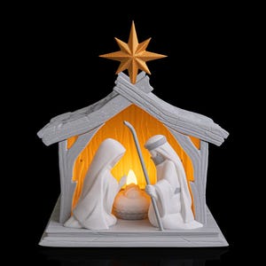 May include: A white nativity scene with a gold star on top. The scene depicts Mary, Joseph, and baby Jesus inside a wooden-style structure. The interior is lit with a warm, inviting glow, creating a peaceful holiday display.