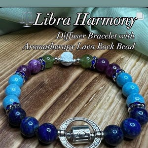 May include: A Libra Harmony diffuser bracelet with aromatherapy lava rock beads. The bracelet features a variety of colorful beads, including blue, purple, and green, and a silver-toned charm with the Libra symbol. The text "It's Libra season!" is visible.