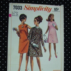 May include: Simplicity sewing pattern number 7033 for Junior Petites, size 9jp, bust 32 1/2 inches. The pattern includes three dress designs: a floral print dress, a solid orange dress, and a solid pink dress. The pattern is for dresses that are 5'1" and under.