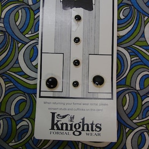 May include: A white card with a tuxedo shirt illustration and black studs and cufflinks. The card reads "Knights Formal Wear" and instructions for returning formal wear rentals.