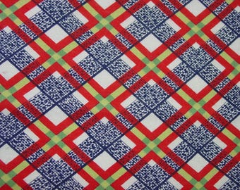May include: Close-up of a fabric with a repeating geometric pattern. The design features red, blue, and green lines forming a grid over a white background. The blue sections have a textured appearance.