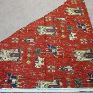 May include: A piece of red fabric with a repeating pattern of architectural designs, figures, and palm trees. The fabric has a white border with text that reads "CALIPH'S PALACE COPYRIGHT MCMXCIV A&G P.J. BAKER LTD PRINTED IN ENGLAND."