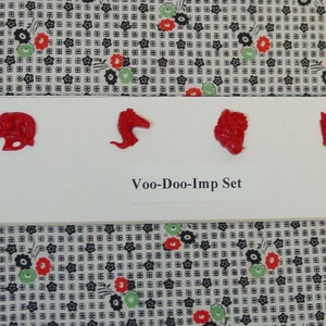 May include: A set of six red plastic imps, each with a different design. The set is labeled "Voo-Doo-Imp Set".