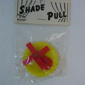 May include: A yellow and red plastic toy windmill with a string attached. The toy is packaged in a clear plastic bag with a white card that reads "Shade Pull" and "Berkander".