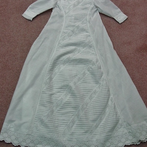 May include: A white christening gown with delicate lace detailing and a gathered skirt.