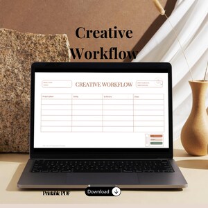 Puede incluir: Una pantalla de portátil que muestra una plantilla digital de planificador de flujo de trabajo creativo con columnas para fase de proyecto, en curso, en revisión y terminado. La interfaz incluye campos de texto para nombre y fecha del proyecto.