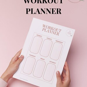 Może przedstawiać: Biały planer treningowy na różowym tle. Planer ma układ tygodniowy, z napisem "Workout Planner" na górze. Widoczne są również teksty "Printable PDF" i "Download".