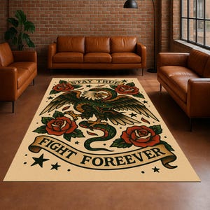 Puede incluir: Alfombra rectangular beige con un diseño de tatuaje tradicional que presenta un águila, una serpiente y rosas. La alfombra tiene las palabras "STAY TRUE" y "FIGHT FOREVER" en una pancarta.