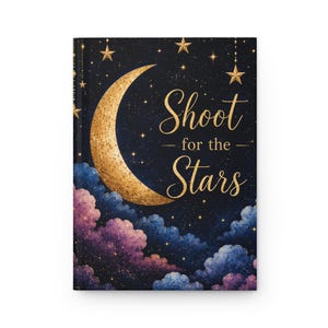 May include: A hardcover journal featuring a dark navy night sky background with a large textured gold crescent moon and gold stars. The text Shoot for the Stars is printed in gold script. The bottom displays purple and blue clouds with gold speckles.
