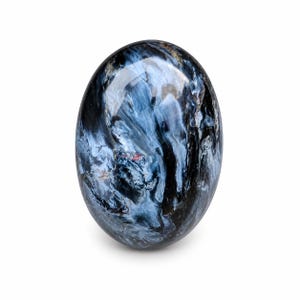 Könnte beinhalten: Oval geschliffener Edelstein mit einem wirbelnden Muster aus tiefen Blautönen, Schwarz und Gold. Der Stein hat eine glänzende, reflektierende Oberfläche. Der Edelstein ist vor einem weißen Hintergrund platziert.