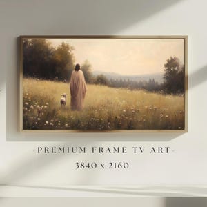 May include: A framed landscape painting depicts a figure in a flowing robe walking in a field with a lamb. The artwork is set in a golden frame and features a serene pastoral scene with soft colors. Text at the bottom reads "- PREMIUM FRAME TV ART - 3840 x 2160".