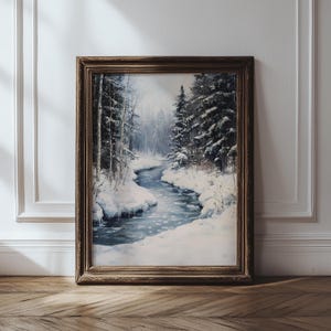 Peut inclure: Peinture encadrée d'un paysage hivernal. L'œuvre représente une rivière enneigée serpentant à travers une forêt de conifères. La peinture est dans un cadre en bois foncé, ajoutant une touche classique à la scène hivernale.