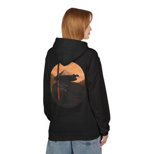 May include: Black hooded sweatshirt featuring a circular graphic on the back. The graphic depicts a samurai with a sword against a sunset backdrop. The design includes shades of orange, red, and black.