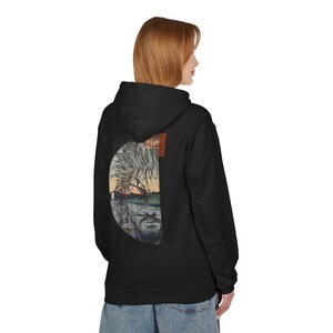 Może przedstawiać: Czarna bluza z kapturem z dużą grafiką na plecach przedstawiającą krajobraz i twarz. Grafika jest połączeniem akwareli i stylu szkicu. Bluza ma kaptur i kieszeń kangurka.