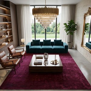 Puede incluir: Una sala de estar con un sofá de terciopelo azul verdoso, dos sillones de cuero marrón y una mesa de centro cuadrada de madera. Una lámpara de araña de oro y cristal cuelga sobre una alfombra púrpura. Un espejo alto con marco dorado.