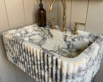 Lavabo de mármol Calacatta Viola para tocador. Lavabo de mármol Calacatta Viola con textura acanalada en tres lados.