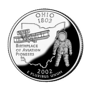 May include: A silver quarter coin depicting a biplane and an astronaut. The coin is inscribed with "OHIO 1803" at the top, and "BIRTHPLACE OF AVIATION PIONEERS" below the biplane. The coin also features the text "2002 E PLURIBUS UNUM".