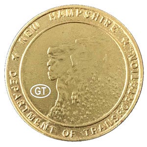 May include: A gold-colored coin featuring a profile of a person and the text "NEW HAMPSHIRE DEPARTMENT OF TRANSPORTATION". The coin also has the letters "GT" inside a white circle.