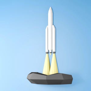 May include: A white rocket launching from a grey platform against a light blue backdrop. The rocket has three sections and emits yellow flames. The design is a low-poly, geometric style.