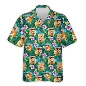 May include: A short-sleeved button-down shirt with a tropical pattern. The shirt features a repeating design of hamsters wearing sunglasses, set against a backdrop of green leaves, pink and yellow flowers, and a turquoise background.